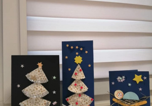 Pocztówki świąteczne - kolorowy papier ozdobiony wyciętymi choinkami, gwiazdkami i prezentami